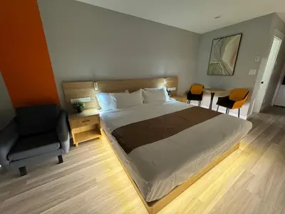 a bedroom with a bed and a desk and a chair at InnTowne Motel II in Hope