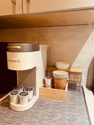 a coffee maker with cups and plates on a shelf at Fort Langley Homestead in Maple Ridge District Municipality