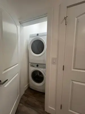 a washer and dryer in a laundry room with a door at Fort Langley Homestead in Maple Ridge District Municipality