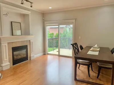 a dining room with a table and a fireplace at 3 Bedrooms 1 Bath in SHARE HOUSE at Coquitlam Central Mall & skytrain in Port Coquitlam
