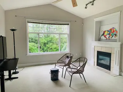 a living room with two chairs and a fireplace at 3 Bedrooms 1 Bath in SHARE HOUSE at Coquitlam Central Mall & skytrain in Port Coquitlam