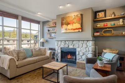 a living room with a couch and a fireplace at 2BR in Blackcomb Greens, Wood Fireplace, Hot Tub Access, Mountain Views, Free Ski Shuttle, Parking in Whistler