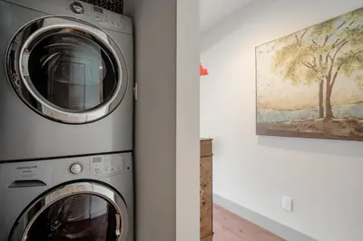 a washer and dryer in a room with a painting at 2BR in Blackcomb Greens, Wood Fireplace, Hot Tub Access, Mountain Views, Free Ski Shuttle, Parking in Whistler