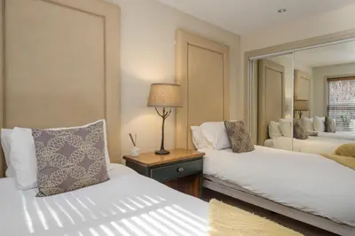 a hotel room with two beds and a mirror at 2BR in Blackcomb Greens, Wood Fireplace, Hot Tub Access, Mountain Views, Free Ski Shuttle, Parking in Whistler