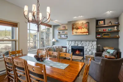 a dining room with a table and a fireplace at 2BR in Blackcomb Greens, Wood Fireplace, Hot Tub Access, Mountain Views, Free Ski Shuttle, Parking in Whistler