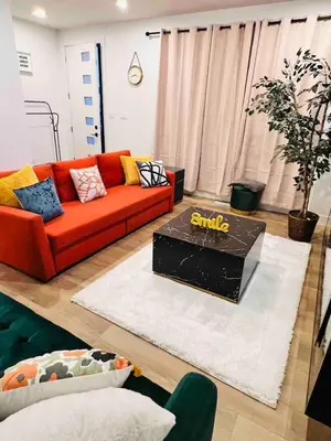 a living room with an orange couch and a table at M21 Luxurious, Downtown River Valley Home, Centrally located, Close to everything in Edmonton
