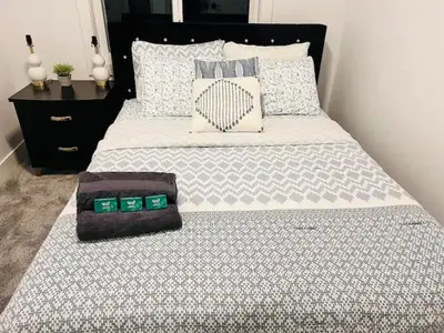 a bed with a black headboard and pillows on it at M21 Luxurious, Downtown River Valley Home, Centrally located, Close to everything in Edmonton