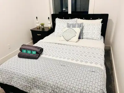 a bedroom with a bed with a black headboard and pillows at M21 Luxurious, Downtown River Valley Home, Centrally located, Close to everything in Edmonton