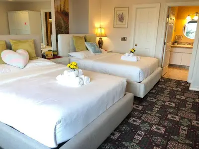 two beds in a hotel room with flowers on them at heated pool, hot tub, 3 AC ensuites, lake view in West Kelowna