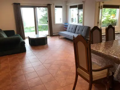 a living room with a couch and a table at heated pool, hot tub, 3 AC ensuites, lake view in West Kelowna