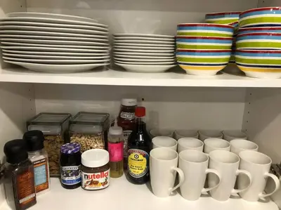 a shelf with cups and plates and other dishes at heated pool, hot tub, 3 AC ensuites, lake view in West Kelowna