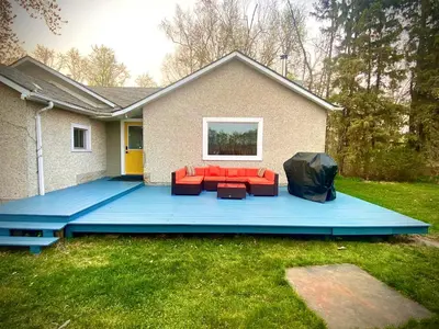 a large blue deck with a couch and chairs on it at DreamLand Farms, Edmonton in Duffield