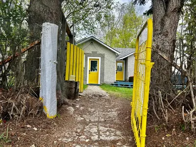 a yellow fence in front of a house at DreamLand Farms, Edmonton in Duffield