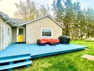 a deck with a couch and chairs on a house at DreamLand Farms, Edmonton in Duffield