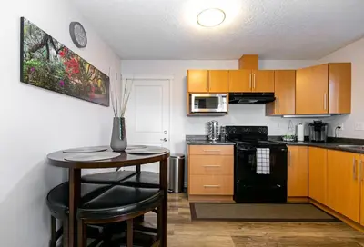 a kitchen with a small table and a stove top oven at Super wow view! in Victoria