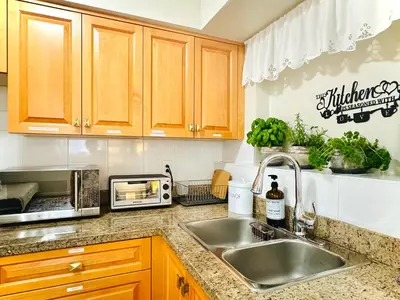a kitchen counter with a sink and a microwave at 2BR 1BA Garden View Guest Suite - King-size Bed - Free Parking in Vancouver