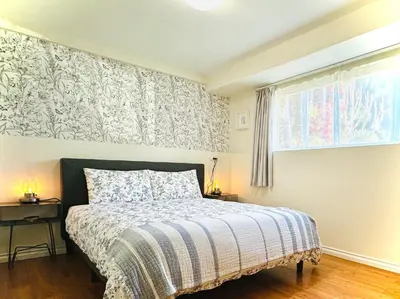 a bedroom with a bed and a window at 2BR 1BA Garden View Guest Suite - King-size Bed - Free Parking in Vancouver