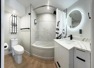 a white bathroom with a tub and a toilet and a sink at PeachView Deluxe Suites 301 in Peachland