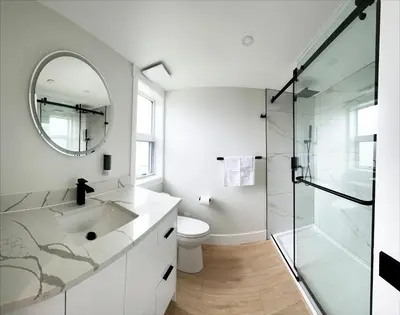 a bathroom with a toilet and a sink and a mirror at PeachView Deluxe Suites 301 in Peachland