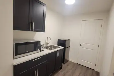 a kitchen with a sink and a microwave at Brand New Suite in the Lakes in Calgary
