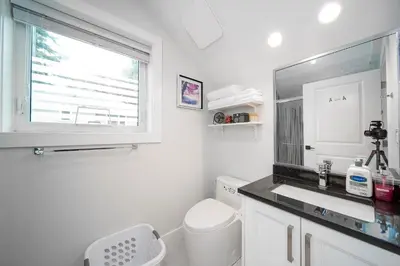 a white bathroom with a sink and a window at New laneway house near Airport, World Cup stadium, Downtown, UBC in Vancouver