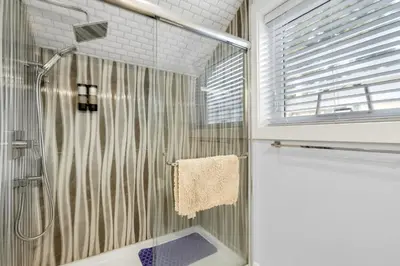 a shower with a glass door in a bathroom at New laneway house near Airport, World Cup stadium, Downtown, UBC in Vancouver