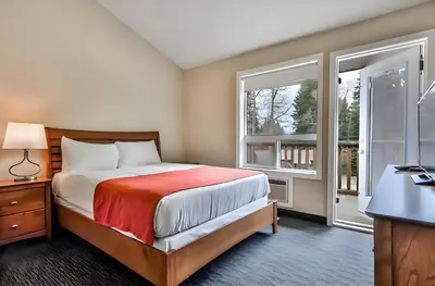 a bedroom with a bed and a large window at Mountain Surrounded Lodge in Harvie Height in Canmore