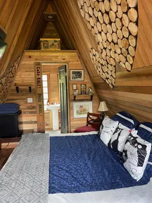 a bedroom with a bed in a log cabin at Bratty Catty Cabin in Powell River
