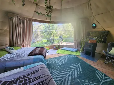 a bedroom with two beds in a tent at D3 Rainforest Getaway Dome- 2Dbl beds in Drumheller