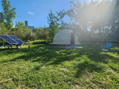a tent and a solar panel in a yard at D3 Rainforest Getaway Dome- 2Dbl beds in Drumheller