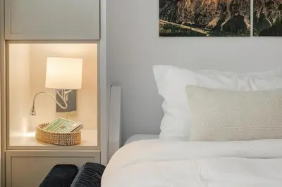a bedroom with a bed and a lamp on a night stand at KING Bed - Premium STUDIO Suite - Ski Valet - Village in Whistler