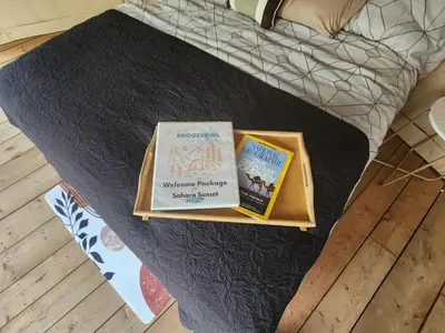 two books are sitting on top of a bed at D6 Sahara Sunset- King Suite Very Private in Drumheller
