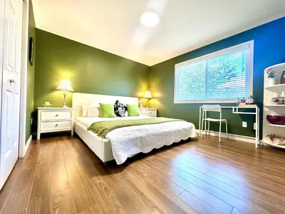 a bedroom with a bed and a green wall at Warm home in Richmond