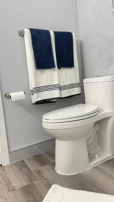 a bathroom with a white toilet and blue towels at Warm home in Richmond