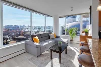 a living room with a couch and large windows at Stylish 2BD Condo in Downtown with Marina View in Vancouver