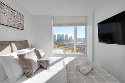 a living room with a white couch and a large window at Stylish 2BD Condo in Downtown with Marina View in Vancouver