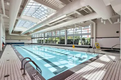 a large indoor swimming pool with a large ceiling at Stylish 2BD Condo in Downtown with Marina View in Vancouver