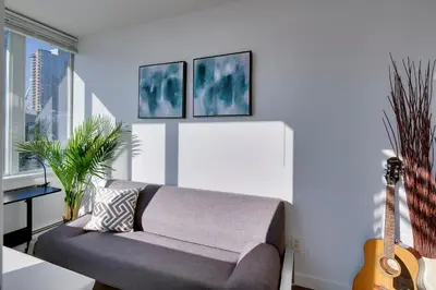 a living room with a couch and a guitar at Stylish 2BD Condo in Downtown with Marina View in Vancouver