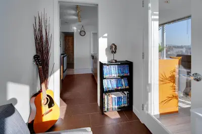 a living room with a guitar and a book shelf with dvds at Stylish 2BD Condo in Downtown with Marina View in Vancouver