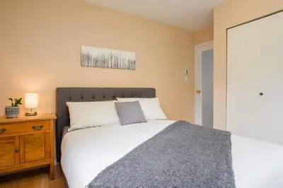 a bedroom with a bed and a wooden nightstand at 4BR in Blueberry Hill Estates, Mountain Views, Large Family Home, Wood Fireplace, Balcony in Whistler