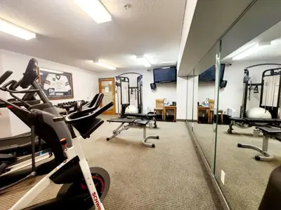 a gym with treadmills and ellipticals in a room at W463 Canmore 2BD 2BT, AC, MT view, Central Location in Canmore