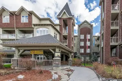 a house with a gate in front of a building at W463 Canmore 2BD 2BT, AC, MT view, Central Location in Canmore