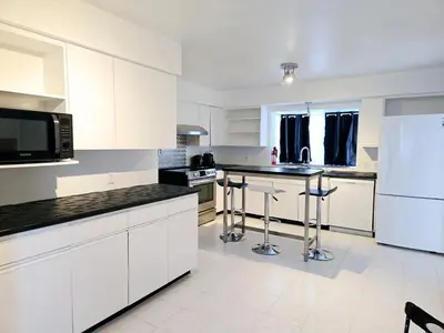 a kitchen with white cabinets and black counter tops at Lovely Cozy Room! with Attached Private Bath in the Heart of Vancouver! Private Parking & Self Check-in! in Vancouver