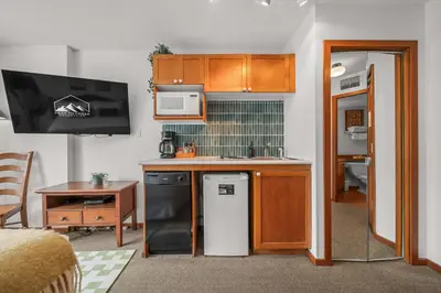 a small kitchen with a sink and a microwave at Mid Century Modern - Studio w Pool & Hot Tub in Whistler