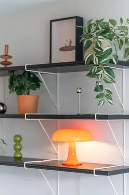 an orange stool sits on a shelf with plants at Mid Century Modern - Studio w Pool & Hot Tub in Whistler