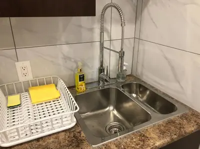 a kitchen sink with a white basket next to it at Heated pool, hot tub, 4 AC lake view bedrooms in West Kelowna