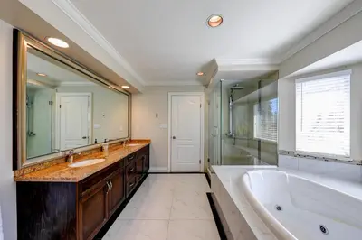 a bathroom with a tub and a large mirror at Beautiful Dunbar Home in Vancouver