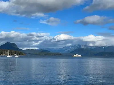 two boats on a large body of water with mountains at Blue House in Gibsons