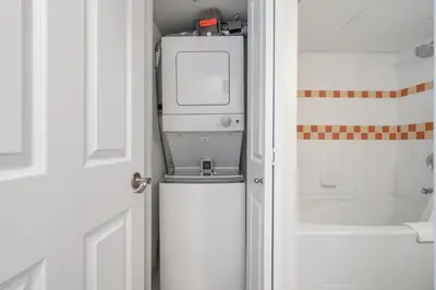 a bathroom with a washer and dryer on top of a door at a fully renovated condo near village centre with MT view and close to lift in Cascade lodge in Whistler