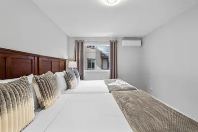 a bedroom with two beds and a window at B111 Hot tub, ACx3, parking, coin laundry, near Banff in Canmore